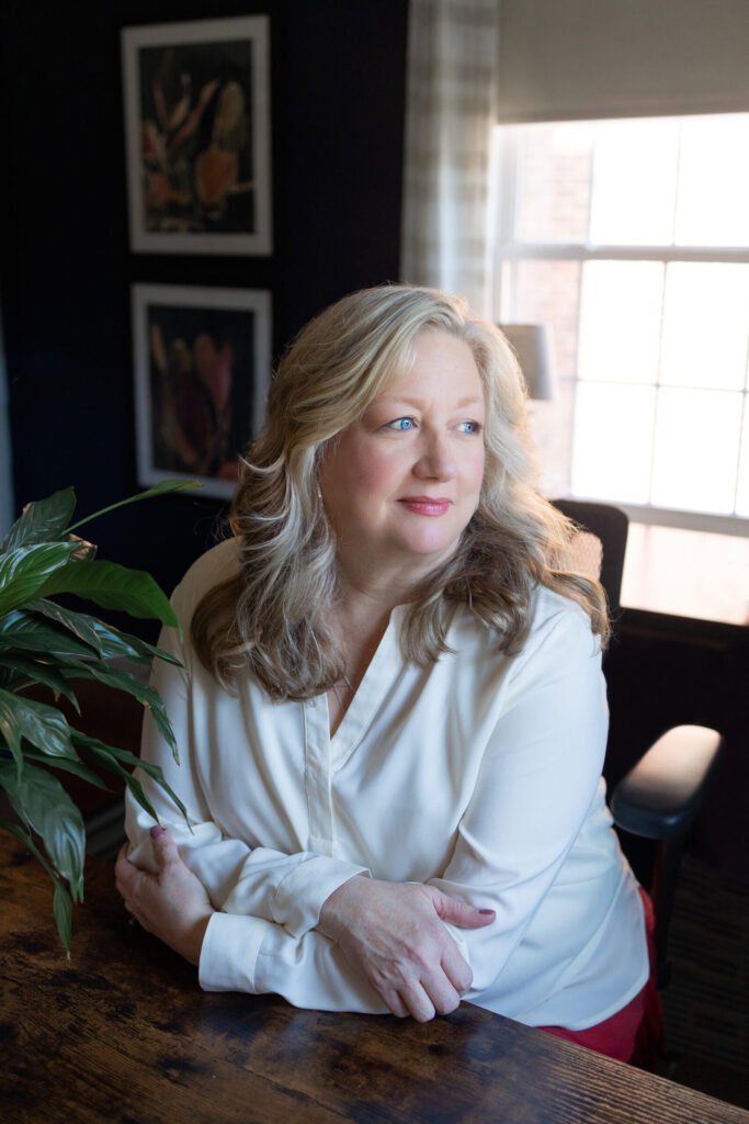 Kate Bergman seated by the window of her therapy office in a white blouse