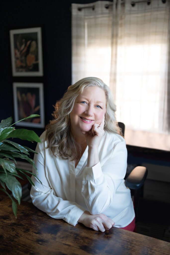 Kate Bergman, somatic therapist, seated with hand on chin in her Beachwood office